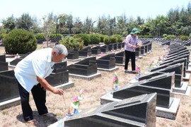Ông Huỳnh Đồng (nguyên Trung đội trưởng Trinh sát-Đoàn 10) và bà Phạm Thị Nhung (cán bộ y tá Đoàn 10) thắp nhang cho các đồng đội tại Nghĩa trang Liệt sỹ Rừng Sác. (Ảnh: Xuân Khu/TTXVN)
