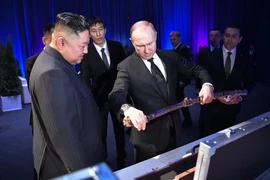 Nhà lãnh đạo Triều Tiên Kim Jong-un (trái) tặng Tổng thống Nga Vladimir Putin (giữa) món quà lưu niệm sau cuộc hội đàm thượng đỉnh tại Vladivostok (Nga) ngày 25/4/2019. (Ảnh: AFP/TTXVN)