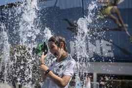 Người dân tránh nóng tại vòi phun nước ở Melbourne, Australia, ngày 24/1/2019. (Ảnh: THX/TTXVN)