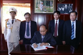 Thủ tướng Nguyễn Xuân Phúc dự và ghi sổ lưu niệm tại Lễ khánh thành Nhà tưởng niệm Chủ tịch Hồ Chí Minh của Công an tỉnh Đắk Nông. (Ảnh: Thống Nhất/TTXVN)