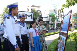 Các chiến sỹ và học sinh xem ảnh tại triển lãm ảnh “Hoàng Sa - Trường Sa trong lòng Quảng Ngãi”. (Ảnh: Đinh Hương/TTXVN)