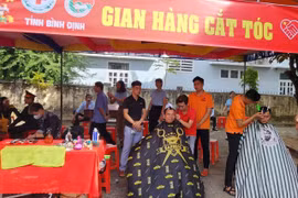 Người dân được cắt tóc miễn phí tại Chương trình Tết Nhân ái. (Ảnh: Sỹ Thắng/TTXVN)