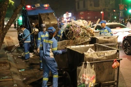 Những công nhân Công ty TNHH Môi trường đô thị Hà Nội (URENCO) - Chi nhánh Hoàn Kiếm vẫn miệt mài làm việc khi gần đến thời điểm đón Giao thừa Tết Quý Mão 2023. (Ảnh: Hoàng Hiếu/TTXVN)