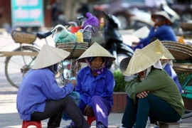 Những người phụ nữ làm nghề lao động tự do tránh nắng dưới bóng râm của những tán cây. (Ảnh: Thanh Tùng/TTXVN)