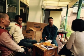 Hai lao động Việt Nam (ngồi bên trái) tại nhà Việt kiều Triệu Tiến Ngọc (ngồi giữa) ở Arncliffe, phía Tây Sydney, Australia. (Ảnh: Sao Băng/Vietnam+)