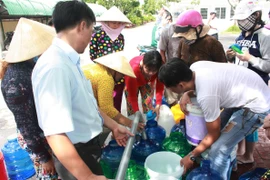 Người dân dùng tất cả các vật dụng có thể sử dụng được để lấy nước ở các xe bồn. (Nguồn: Bùi Trường Giang/Vietnam+)