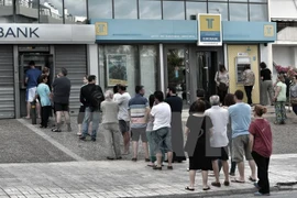 Người dân Hy Lạp xếp hàng chờ rút tiền tại máy rút tiền tự động ở Athens ngày 27/6. (Nguồn: AFP/ TTXVN)