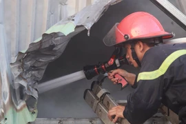 Lực lượng cảnh sát phòng cháy chữa cháy nỗ lực chiến đấu với ngọn lửa. (Ảnh: Minh Sơn/Vietnam+)