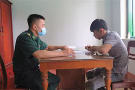 Lực lượng chức năng tiến hành lấy lời khai các đối tượng. (Ảnh: Dư Toán/TTXVN)