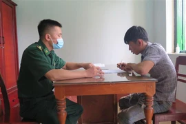Lực lượng chức năng tiến hành lấy lời khai các đối tượng. (Ảnh: Dư Toán/TTXVN)