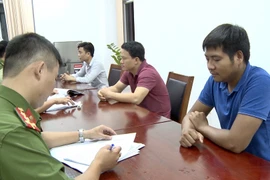 Lấy lời khai của nhóm đối tượng lừa đảo. (Ảnh: TTXVN phát)