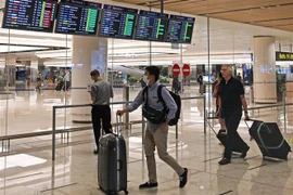 Hành khách tại sân bay quốc tế Changi ở Singapore ngày 16/3/2020. (Ảnh: AFP/TTXVN)
