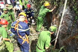 Lực lượng cứu hộ tìm kiếm thi thể nạn nhân. (Ảnh: TTXVN phát)