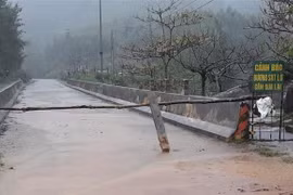 Lực lượng chức năng đặt biển cảnh báo nguy hiểm tại vùng có sạt lở ở xã Cẩm Lĩnh (huyện Cẩm Xuyên, Hà Tĩnh). (Ảnh: TTXVN phát)