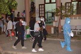 Nhân viên y tế hướng dẫn công dân trở về vào khu vực cách ly tại Tiền Giang. (Ảnh: Nam Thái/TTXVN)