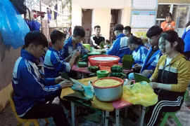 Các em Trường THPT Nguyễn Cảnh Chân, huyện Thanh Chương (Nghệ An) gói bánh chưng ủng hộ đồng bào lũ lụt các tỉnh miền Trung. (Ảnh: TTXVN phát)