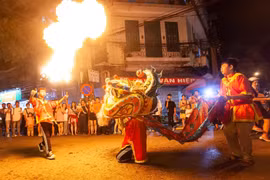 Tiết mục múa lân với lửa tạo nên không khí sôi động trên phố Hàng Chiếu. (Ảnh: Minh Công/TTXVN)