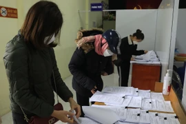 Người dân lấy giấy xác nhận F0 tại phường. (Ảnh: Hoàng Hiếu/TTXVN) 