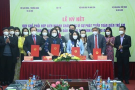 Lễ ký kết ban hành Quy chế phối hợp liên ngành trong triển khai đề án chăm sóc vì sự phát triển toàn diện trẻ em trong những năm đầu đời tại gia đình và cộng đồng. (Ảnh: PV/Vietnam+)