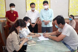 Chi trả tiền hỗ trợ cho người lao động bị ảnh hưởng bởi COVID-19. (Ảnh minh hoạ: Đại Nghĩa/TTXVN)