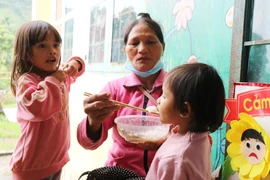 Chăm lo cho trẻ em tại điểm sơ tán cho người dân tránh bão. (Ảnh: Phạm Cường/TTXVN)