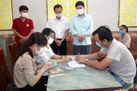 Chi trả tiền hỗ trợ cho người lao động bị ảnh hưởng bởi COVID-19. (Ảnh: Đại Nghĩa/TTXVN)