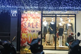 Các cửa hàng thời trang giảm giá lớn thu hút rất đông khách hàng. (Ảnh: PV/Vietnam+)