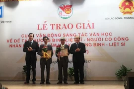 Bộ trưởng Bộ Lao động-Thương binh và Xã hội Đào Ngọc Dung trao giải cho các tác giải đoạt giải Nhất. (Ảnh: PV/Vietnam+)