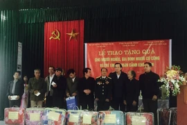 Bộ trưởng Bộ Lao động-Thương binh và Xã hội Đào Ngọc Dung tặng quà cho gia đình người có công.(Ảnh: PV/Vietnam+)