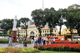 Khách quốc tế vui chơi trong vườn hoa trước Bưu điện Trung tâm và Nhà thờ Đức Bà Thành phố Hồ Chí Minh. (Ảnh: Hồng Đạt/TTXVN)