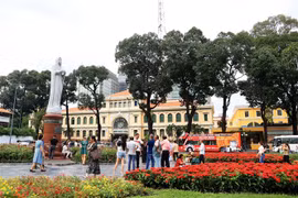 Khách quốc tế vui chơi trong vườn hoa trước Bưu điện Trung tâm và Nhà thờ Đức Bà Thành phố Hồ Chí Minh. (Ảnh: Hồng Đạt/TTXVN)