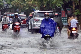 Mưa kéo dài khiến nhiều tuyến đường ngập cục bộ, gây khó khăn cho việc di chuyển của người dân. (Ảnh: Hồng Giang/TTXVN)