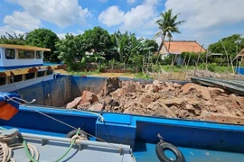 Các phương tiện thủy vận chuyển đất không rõ nguồn gốc bị tạm giữ. (Ảnh: TTXVN phát)