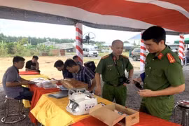 Lực lượng phá án thu giữ vật chứng tại sàn giao dịch bất động sản ma, xã An Viễn, huyện Trảng Bom. (Ảnh: TTXVN phát)