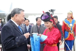 Thiếu nữ Mông Cổ dâng bánh sữa theo phong tục truyền thống và tặng hoa đón Tổng Bí thư, Chủ tịch nước Tô Lâm tại sân bay Thành Cát Tư Hãn (Chinggis Khaan International Airport) ở Thủ đô Ulan Bator. (Ảnh: Trí Dũng/TTXVN)