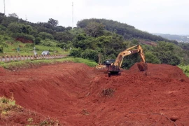 Máy múc san gạt, di chuyển các khối đất để bảo vệ hành lang đường Hồ Chí Minh. (Ảnh: Hưng Thịnh/TTXVN)