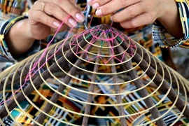 Công đoạn làm mô (khung) nón lá Thới Lai. (Ảnh: Thu Hiền/TTXVN)
