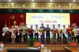 Ông Lê Trung Kiên, Trưởng ban Ban quản lý Khu kinh tế Hải Phòng (thứ 6 từ trái sang) và Đại tá Bùi Xuân Thắng (mặc quân phục) chúc mừng các doanh nghiệp. (Ảnh: Minh Thu/TTXVN)
