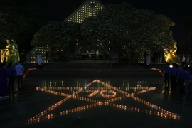 Những ngọn nến xếp thành hình ngôi sao và số 70 tại Nghĩa trang A1. (Ảnh: Xuân Tư/TTXVN)