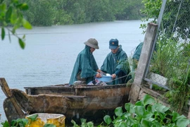 Trời mưa cộng thêm nước sông lên cao khiến việc tìm kiếm, trục vớt tài sản gặp không ít khó khăn. (Ảnh: Thanh Liêm/TTXVN)