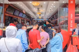 Nhiều người xếp hàng để chờ đến lượt mua, bán vàng tại cửa hàng Bảo Tín Minh Châu. (Ảnh: Hoàng Hiếu/TTXVN)
