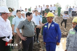 Thủ tướng Phạm Minh Chính chúc Tết công nhân, người lao động đang thi công đường Vành đai 3 đoạn qua Thành phố Hồ Chí Minh. (Ảnh: Dương Giang/TTXVN)