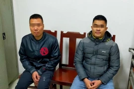 Hai đối tượng bị triệu tập làm việc tại cơ quan công an. (Ảnh: TTXVN phát)