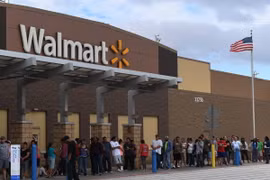 Người dân xếp hàng bên ngoài cửa hàng Walmart ở Houston, Texas, Mỹ. (Ảnh: AFP/TTXVN)