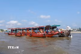 Hai du khách người Mỹ thưởng thức bữa sáng trên ghe ở Chợ nổi Cái Răng. (Ảnh: Thanh Liêm/TTXVN)