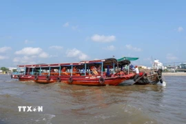 Hai du khách người Mỹ thưởng thức bữa sáng trên ghe ở Chợ nổi Cái Răng. (Ảnh: Thanh Liêm/TTXVN)