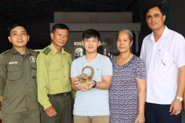 Cháu Mã Đoàn Nhật Thiên bàn giao cá thể Tê Tê cho hạt kiểm lâm huyện Bù Đăng (Bình Phước). (Ảnh: Đậu Tất Thành/TTXVN)