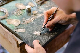 Trình diễn kỹ thuật nghề đậu bạc. (Ảnh: Thanh Tùng/TTXVN) 