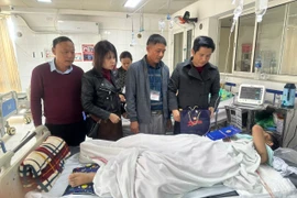 Chủ tịch Công đoàn ngành Giáo dục Hà Nội Đỗ Văn Nam tặng quà cho em Đ.T.M. (Ảnh: TTXVN phát)