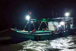 Tàu cá CT 09999 TS đang được tàu BP18-13-01 của Hải đội 2 Biên phòng Sóc Trăng kéo ra khỏi khu vực mắc cạn. (Ảnh: TTXVN phát)